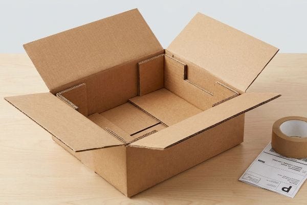 E-commerce Packaging Box Open corrugated e-commerce packaging box with internal dividers, packing tape, and shipping label for direct-to-consumer shipping.