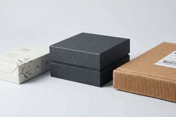 Three Types of Boxes White folding carton for Herbal Capsules, dark gray rigid setup box, and brown E-flute corrugated mailer.
