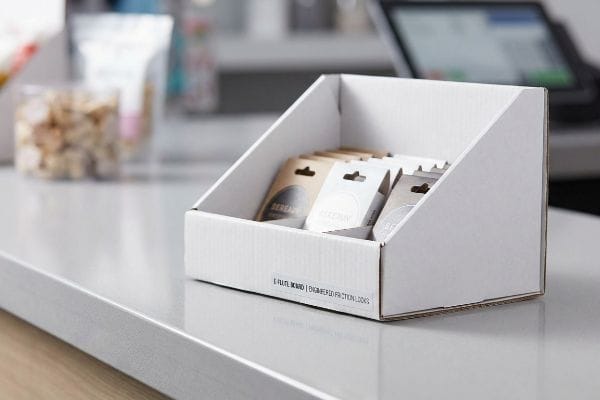 E-Flute Counter Display Box White E-Flute Board counter display box with Engineered Friction Locks, holding small cereal sample packs on a retail counter.