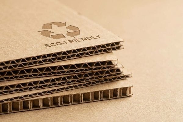 Corrugated cardboard sheets display a recycle symbol and 'Eco-Friendly' text, highlighting sustainable packaging material.