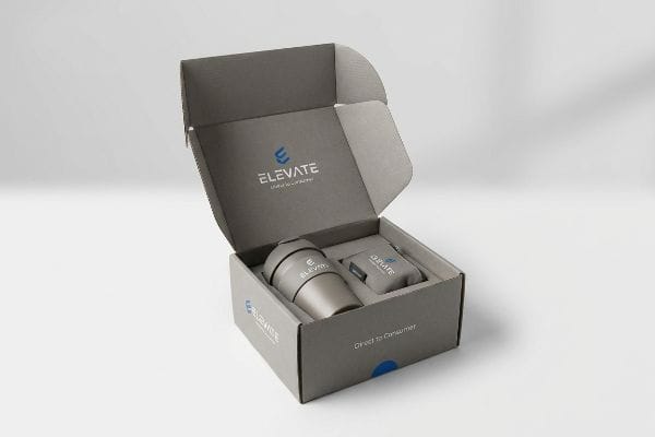 Elevate DTC Product Box An open gray Elevate Direct to Consumer DTC product box reveals a reusable cup and a small gadget, both branded Elevate.