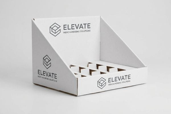 Elevate Theken-Displaybox Ein leerer, weißer Wellpapp-Thekenaufsteller mit dem Logo von „Elevate Merchandising Solutions“ ist für den Einzelhandel konzipiert.