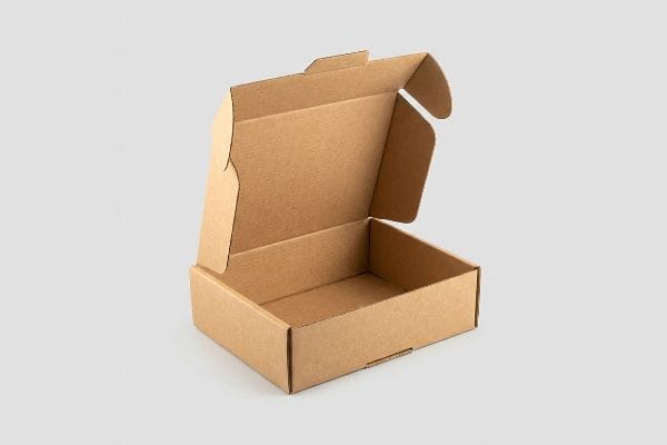 An open, empty brown corrugated mailer box with interlocking flaps and friction-locking tabs, ready for secure transit.