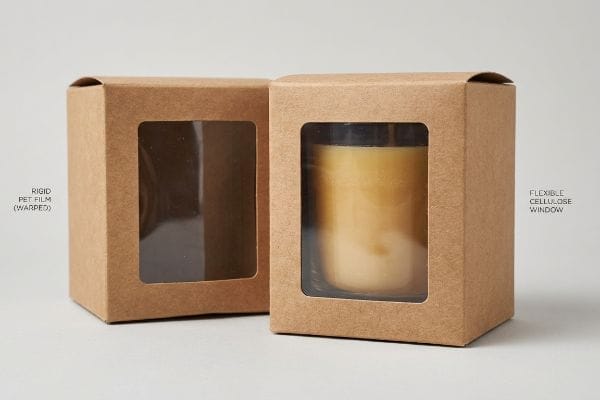 Kraft paper window boxes, one with Rigid Pet Film (Warped) and another with a Flexible Cellulose Window, ideal for candle packaging.