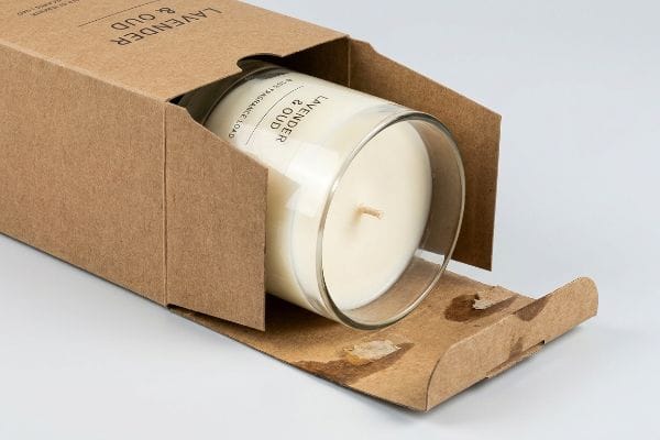 Fragrance Oil Migration Candle Brown kraft paper box with a Lavender & Oud candle, showing fragrance oil migration stains on the bottom flaps.