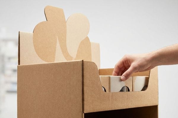 Retail Display Product Access Natural brown corrugated cardboard retail display with a hand reaching for products, showcasing frictionless access and a die-cut header.