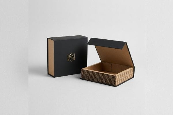 Two elegant custom boxes, one closed with a gold foil logo, the other open revealing its corrugated kraft interior.