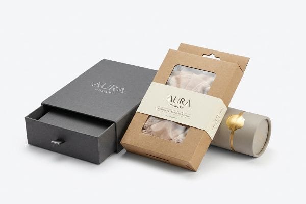 Aura Hosiery Packaging Aura Hosiery custom packaging featuring a dark grey drawer box, kraft hang-tab box with window, and a premium cylindrical tube.