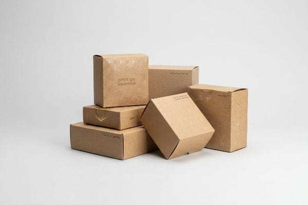 Kraft Box Finish Options Arrangement of kraft boxes showcasing different finishing options, including Spot UV Varnish, Matte Lamination, Aqueous Coating, and Foil Stamping.
