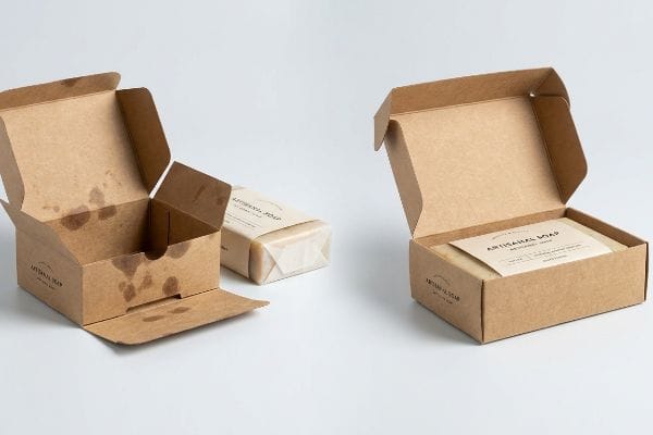 Kraft paperboard Artisanal Soap boxes, one showing internal oil stains, another holding a Natural Soap bar.