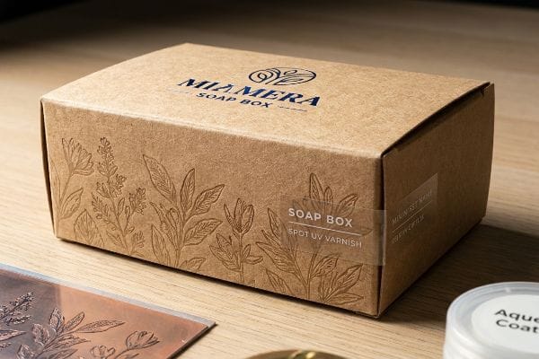 Miamera Soap Box Packaging Miamera kraft paper soap box with botanical debossing, a "Spot UV Varnish" label, and an "Aqueous Coat" container.