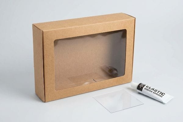 Kraft Window Patch Kit Brown kraft paper window box, clear polymer film window patch, and Elastic Window Adhesive tube.