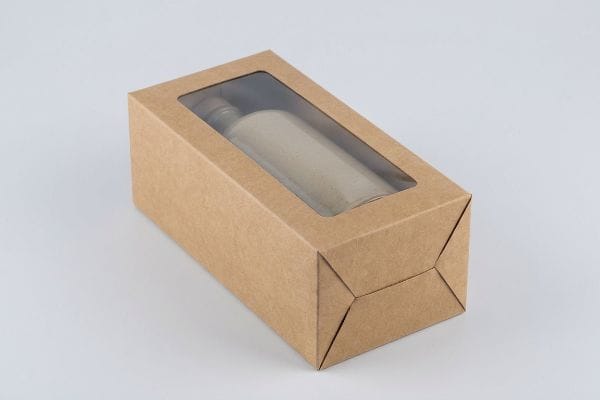 茶色のクラフト紙製の窓付きカートンには、つや消し加工の円筒形ボトルとストッパーが収められており、小売店での商品陳列に最適です。.