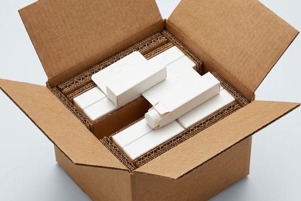 Lip Balm Shipping Box Open corrugated master carton with white lip balm boxes, secured by internal dividers, demonstrating protective shipping.