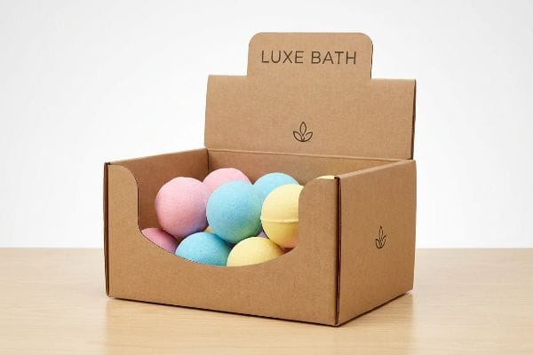 Luxe Bath Bomb Display Corrugated cardboard display box for Luxe Bath, with a die-cut swoop profile revealing vibrant pink, blue, and yellow bath bombs.