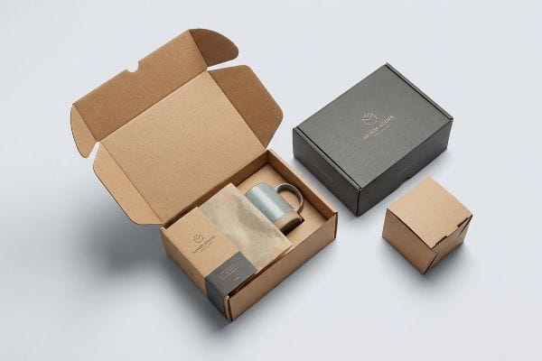 Mailer Box Product Packaging Product packaging features an open kraft mailer box with a ceramic mug and Maison Roche branding, alongside a closed dark grey box.