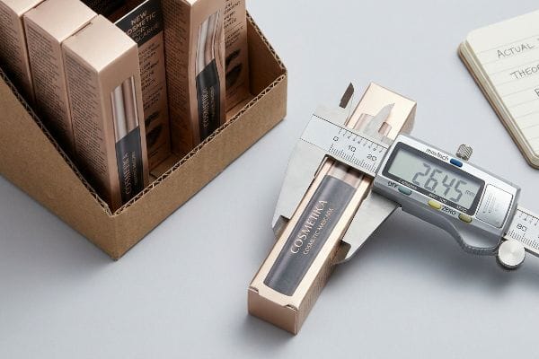 Measuring Mascara Carton Digital caliper measures a rose gold Cosmétika Cosmetic Mascara carton at 26.45 mm, preventing retail packaging bulge.