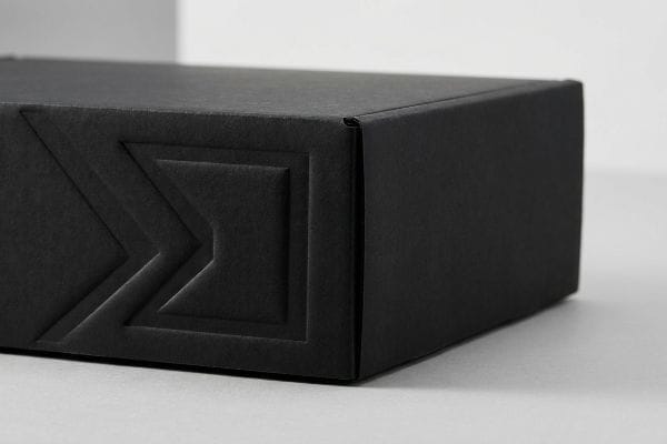 Matte black luxury packaging box with a deep debossed geometric pattern, emphasizing a premium tactile 3D finish.