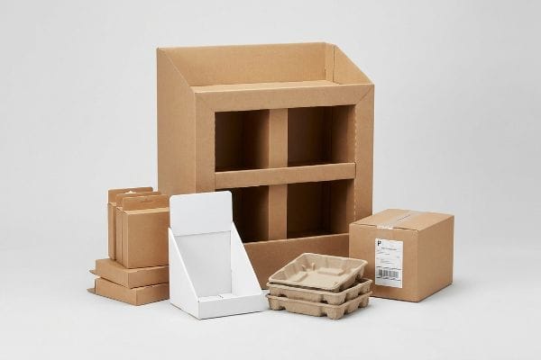 Retail Packaging Solutions Various retail packaging solutions: a corrugated floor display, white countertop unit, brown shipping boxes with a "P" label, and molded fiber trays.