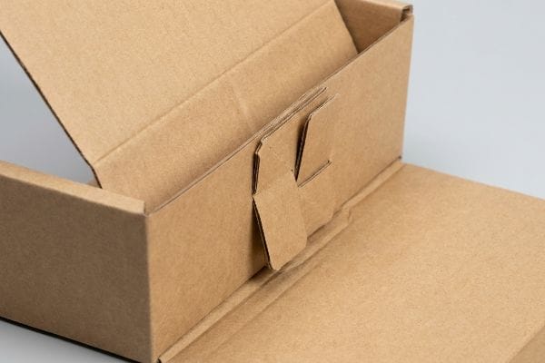 Brown corrugated cardboard box with an internal origami-style paper lock, demonstrating mono-material packaging.