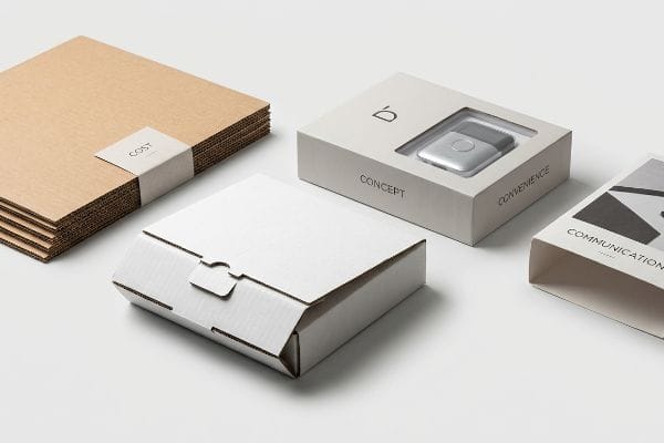 Brown corrugated sheets labeled 'Cost', a grey box with 'Concept' and 'Convenience' displaying a silver device, a white interlocking cardboard box, and a 'Communication' sleeve.