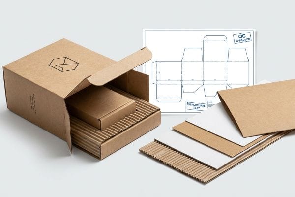 Retail Packaging Structural Test Packaging materials and a structural test blueprint are displayed with an open corrugated box, showing internal protection and a 'QC Approved' stamp.
