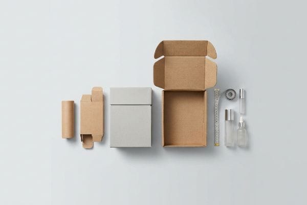 Cosmetic packaging components: open corrugated mailer, grey rigid box, brown folding carton, tube, and clear bottles.