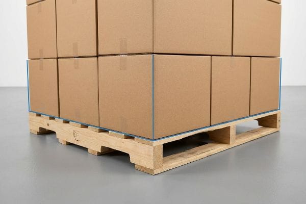 パレットの突出はゼロ 茶色の段ボール箱が木製パレットの上に完璧に整列しており、角の圧縮強度を最大限に高めるため、はみ出しは一切ない。.