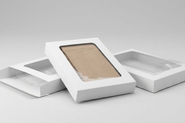 Pantyhose Packaging Windows White rectangular packaging boxes with clear plastic viewing windows, one displaying a light brown fabric item, ideal for pantyhose or hosiery.