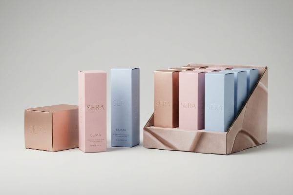 Sera Luma Display Tray Soft touch paperboard Sera Luma cosmetic packaging in rose gold, pink, and blue, with a retail display tray.