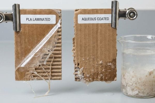 PLA vs Aqueous Repulping PLA Laminated corrugated board peels, while Aqueous Coated board dissolves into a beaker, showcasing repulping contrast.