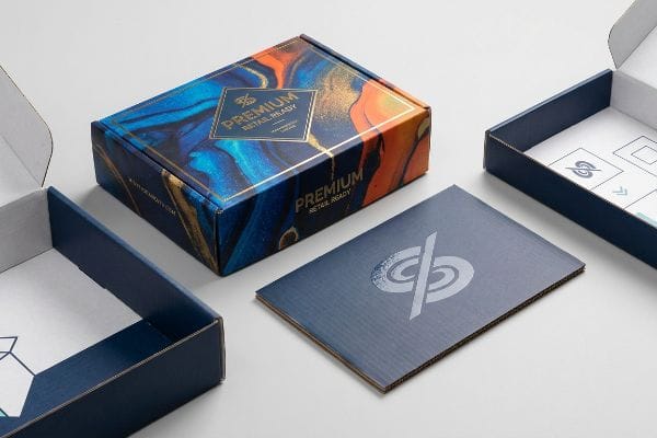 Premium Corrugated Retail Packaging Showcasing premium retail-ready corrugated packaging, a vibrant blue and orange box with gold accents, an open box, and a flat printed sheet.