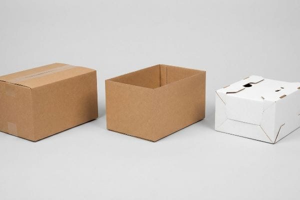 Three distinct corrugated box types: a sealed brown RSC, an open brown HSC, and a white die-cut folding carton.