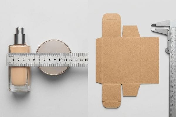 Precise measurement of a foundation bottle and compact powder with a ruler, alongside an unfolded cardboard box template and caliper for ideal makeup box dimensions.