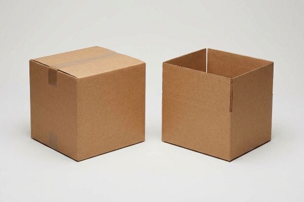 Brown corrugated cardboard boxes, a sealed Regular Slotted Container (RSC) and an open-top Half Slotted Container (HSC), illustrating packaging structural integrity.