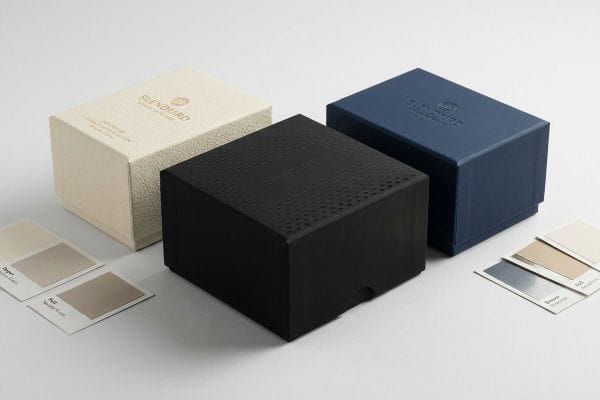 Luxury Packaging Color Swatches Textured cream, black debossed, and navy Slendiard luxury packaging boxes with foil accents, shown with color swatches for tactile finishes.