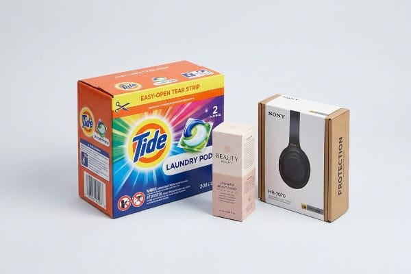 علبة برتقالية اللون من كبسولات غسيل الملابس تايد (208 لتر) مزودة بشريط سهل الفتح، وعلبة مستحضرات تجميل بيوتي إلكسير، وعلبة سماعات رأس سوني HH-7070 مع غطاء حماية.