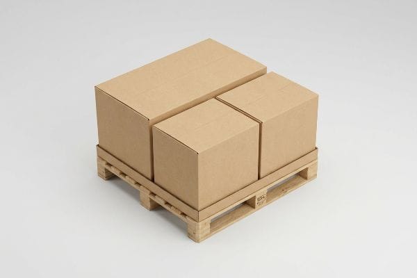 Plain brown corrugated cardboard boxes, including one large and two smaller, neatly arranged on a wooden shipping pallet.