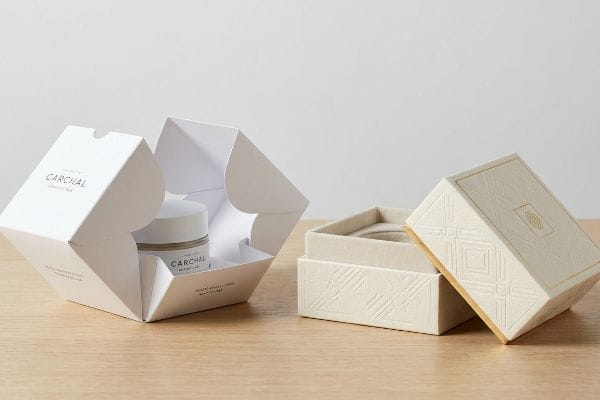 Cosmetic Box Packaging Types Two premium cosmetic boxes: a white Carchal folding carton with a jar and a beige textured rigid setup box with gold foil.