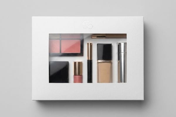 Cosmetic Window Box Set White folding carton window box showcasing a cosmetic gift set with blush, foundation, and mascara through a clear PET plastic panel.