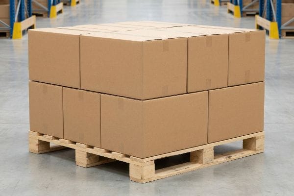 Palletized Boxes Warehouse Logistics Brown corrugated master cartons double-stacked on a wood pallet in a warehouse, showcasing zero-overhang logistics.