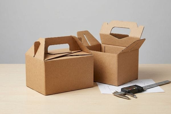 ゲーブルボックスエンジニアリング 精密な包装設計のために、特注の段ボール製ゲーブルボックス2個(1個は開放型、もう1個は閉鎖型)、デジタルノギス、および構造設計図。.